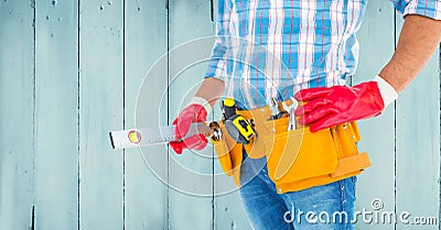 Handyman with tool belt and sprit level against wooden background Stock Photo