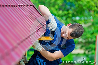 Handyman with the tool during the repair of the roof Stock Photo