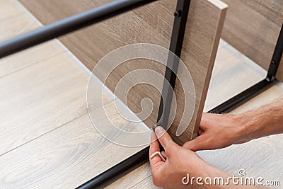 Handyman uses tools for furniture to fix the shelf on the book rack Stock Photo