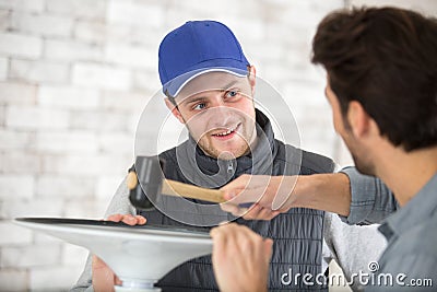 handyman using mallet to locate rubber seal into groove Stock Photo