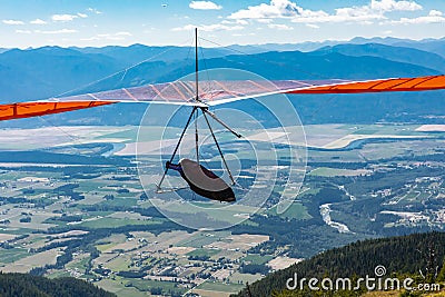 Hang gliding over valley farmlands and mountains Stock Photo