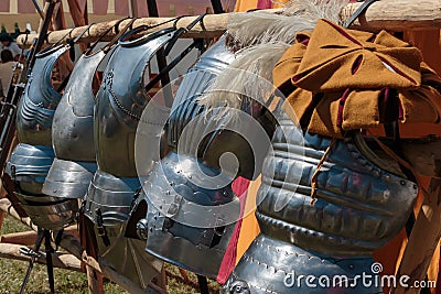 Hanged Metallic Armors in Line in front of Red and Yellow Tent Stock Photo