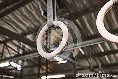 Hanging acrobat rings in emtpy gym. Gymnastic rings hanging in a gym. Gym equipment hanging in an empty gym. Exercise Stock Photo