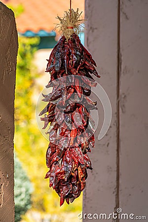 Hanging chile peppers on the outside of house as both a decoration and delicacy for cooking and spices in recipe Stock Photo