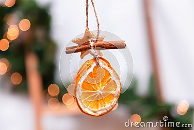 Hanging Christmas decoration of dried oranges, tangerine and cinnamon stars. holiday concept. blurred background Stock Photo