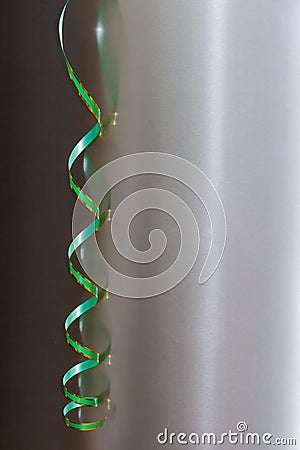 Hanging curly paper streamer against the metal reflective surface Stock Photo
