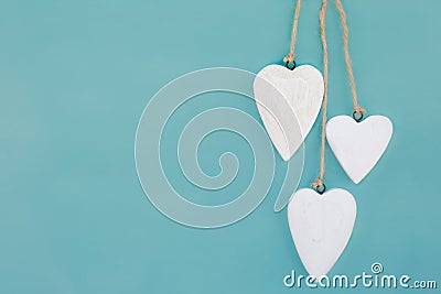 Hanging hearts and turquoise background in country style. Chic, card. Stock Photo