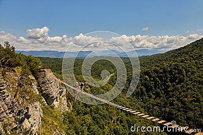 Hanging ladder over a precipice in the mountains. Walk along the stairs over a deep abyss. Stock Photo