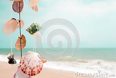 Hanging seashells decoration with tropical beach and blue sky background. Stock Photo