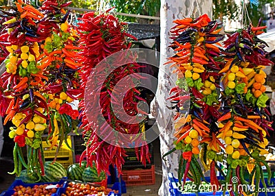 Hanging strings of mixed hot chili peppers for sale at Sineu market, Majorca, Spain Stock Photo