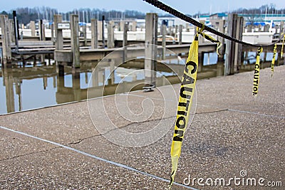 Hanging yellow caution tape strips Stock Photo