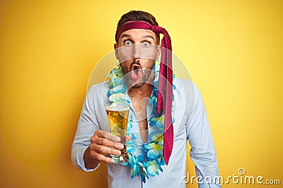 Hangover business man drunk and crazy for hangover wearing tie on head drinking beer scared in shock with a surprise face, afraid Stock Photo