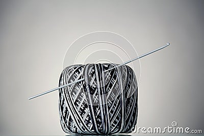 Hank of black and white yarn and crochet hook, on grey Stock Photo