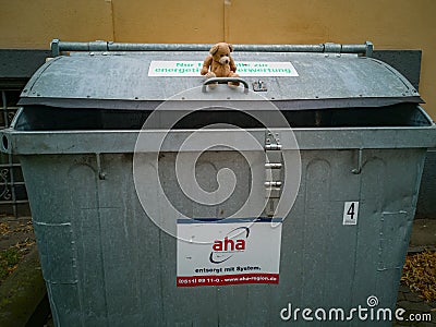 Hannover, Lower Saxony, Germany - July, 29, 2019: a lonely little teddy bear sitting on a metal garbage container Editorial Stock Photo