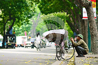 HANOI -24th April, 2013, Unidentified flower vendor in a street in Hanoi Vietnam. This is a specific tradition in Hanoi Editorial Stock Photo