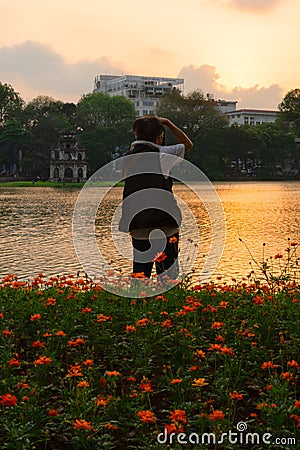 Photographer capturing Hoan Kiem Lake at sunset Editorial Stock Photo