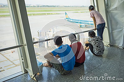 Hanoi, Vietnam - July 12, 2015: Asian customers look at airplane while waiting for boarding time at Noi Bai International Airport, Editorial Stock Photo