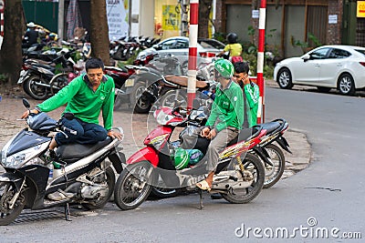 Hanoi, Vietnam - July 7, 2017: Gab motorbike driverswaiting for customer on Ba Trieu street. Entered Vietnam in 2014, Grab growing Editorial Stock Photo