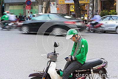 Hanoi, Vietnam - July 7, 2017: Grab motorbike driver waiting for customer on Ba Trieu street. Entered Vietnam in 2014, Grab growin Editorial Stock Photo