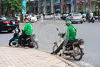 Hanoi, Vietnam - July 7, 2017: Grab motorbike driver waiting for customer on Ba Trieu street. Entered Vietnam in 2014, Grab growin Editorial Stock Photo