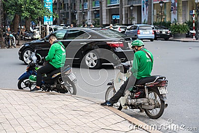 Hanoi, Vietnam - July 7, 2017: Grab motorbike driver waiting for customer on Ba Trieu street. Entered Vietnam in 2014, Grab growin Editorial Stock Photo