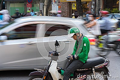 Hanoi, Vietnam - July 7, 2017: Grab motorbike driver waiting for customer on Ba Trieu street. Entered Vietnam in 2014, Grab growin Editorial Stock Photo