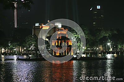 The ancient Turtle Tower in the middle of the Hoan Kiem lake in the city of Hanoi illuminated at night Editorial Stock Photo