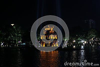 The ancient Turtle Tower in the middle of the Hoan Kiem lake in the city of Hanoi illuminated at night Editorial Stock Photo