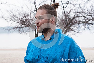 Hansome bearded man with hair bun and make up looking away and speaking Stock Photo