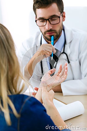 Hansome young male doctor checking hand pain for patient in the medical office. Stock Photo