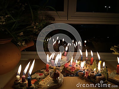 Hanukka candeles lit on a window shelf Stock Photo