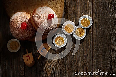 Hanukkah donutsand traditional spinning dreidel on a wooden board. Close up Stock Photo