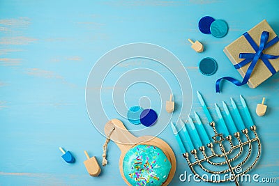 Hanukkah greeting card with traditional donuts, menorah and gift box on blue background Stock Photo