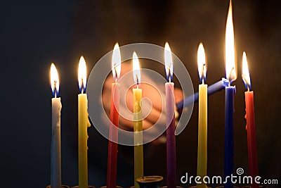 Jewish Woman lighting Hanukkah Candles in a menorah. Stock Photo