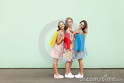 Happiness beautiful three friends in glasses with colorful packets after shopping Stock Photo
