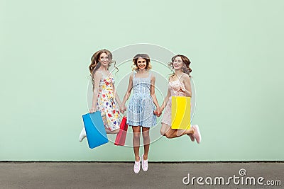 Happiness beautiful three friends jumping from happy with colorful packets after shopping. Stock Photo