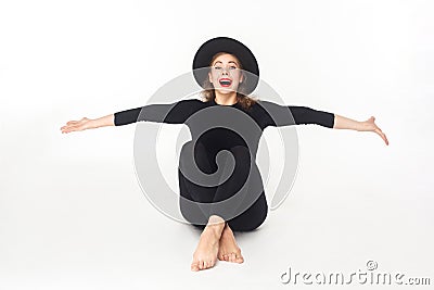 Happiness beautiful woman in hat, sitting on floor. Stock Photo