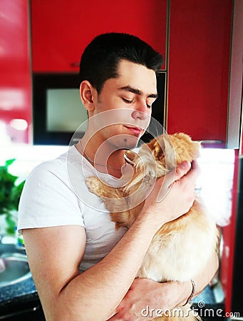 Happiness. Cat with Young Man. Orange Persian Cat. Lover Man, Hugging and Cuddling his Happy Domestic Cat Pet. Love to the animals Stock Photo