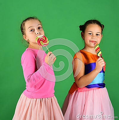 Happiness and dessert concept. Children eat big colorful sweet caramels. Stock Photo