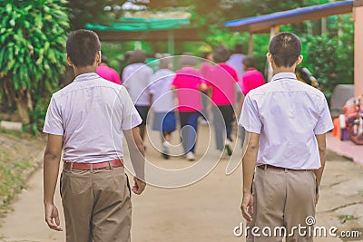 Happiness male students walk behind his girlfriends Editorial Stock Photo