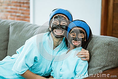 happiness of mother and child when using facial clay masks together Stock Photo