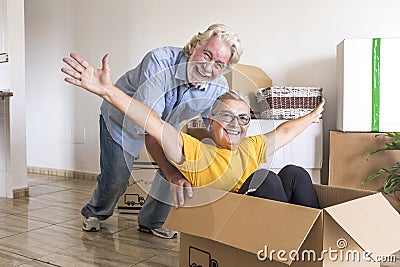 Happiness of two senior people in empty room playing like children in relocation happy for new beginning like retired with moving Stock Photo