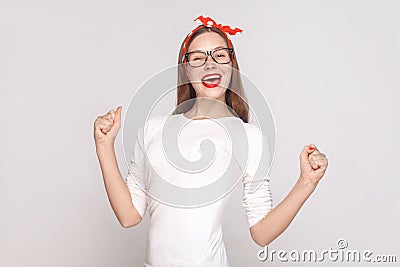 happiness and victory portrait of beautiful emotional young woman in white t-shirt with freckles, black glasses, red lips and Stock Photo