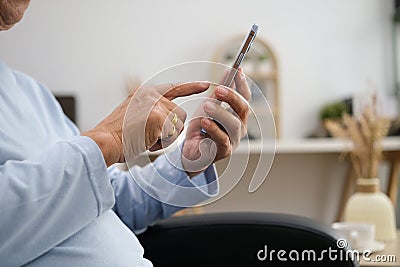 Happiness of wellness elderly asian man with white hairs sitting on sofa using mobile phone Stock Photo