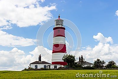 Happisburgh lighthouse under fluffy white clouds. Editorial Stock Photo