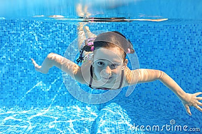 Happy active child swims underwater in pool Stock Photo