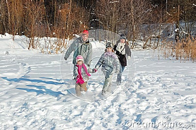 Happy family walks in winter, having fun and playing with snow outdoors on holiday weekend Stock Photo