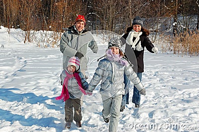 Happy family walks in winter, having fun and playing with snow outdoors on holiday weekend Stock Photo