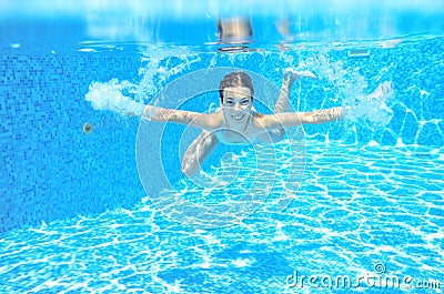 Happy active underwater child swims in pool, beautiful healthy girl swimming Stock Photo