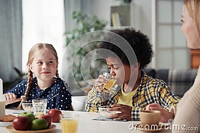 Children having breakfast with mother Stock Photo